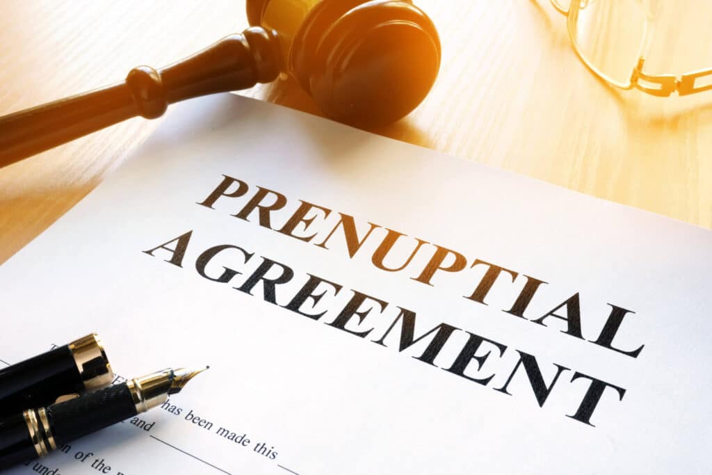 Prenuptial Agreement Lawyer preparing a legal document with a gavel and pen on a wooden desk